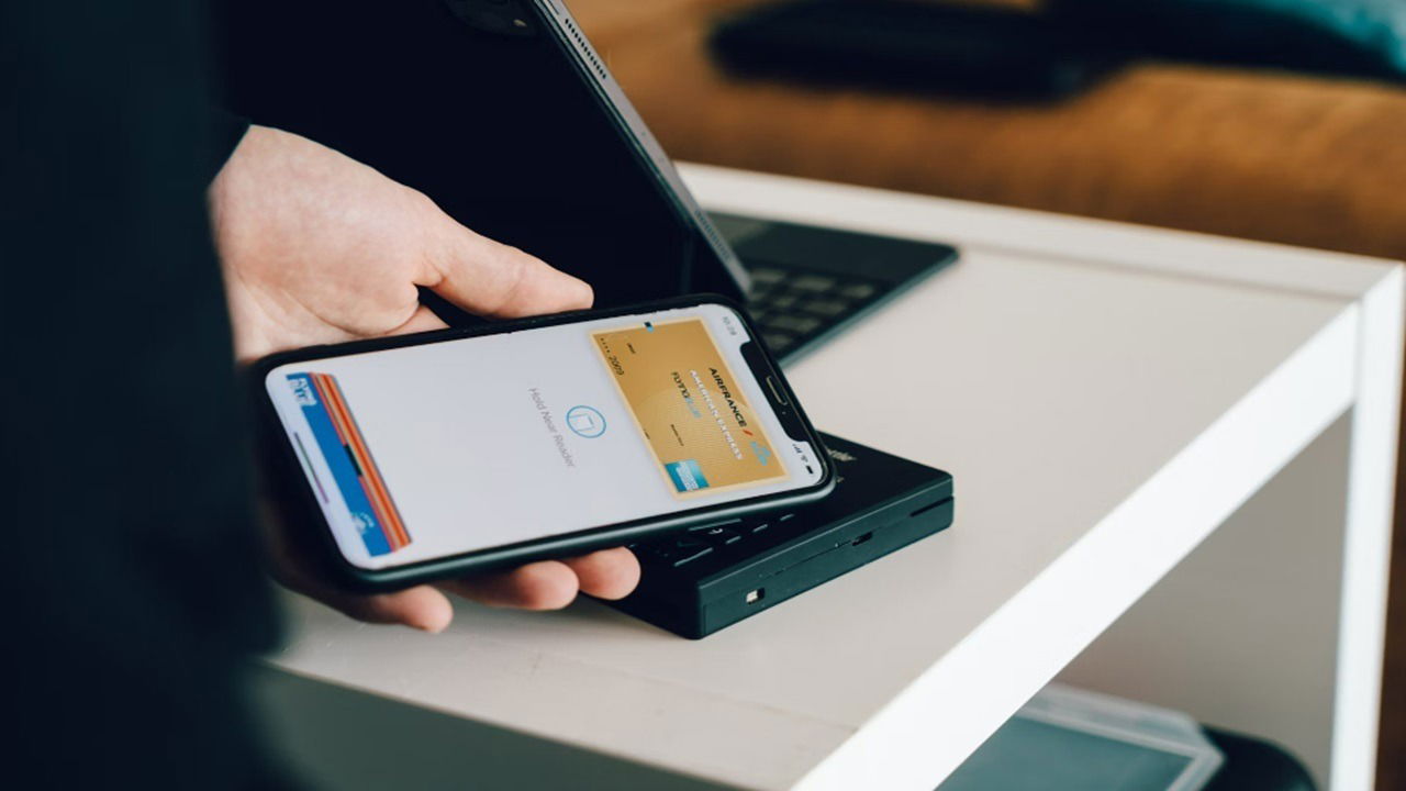 Person using Apple Pay at a counter.