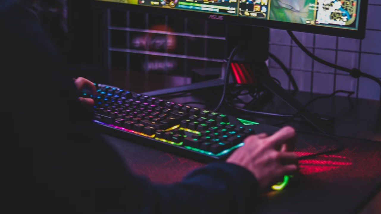 Person using gaming keyboard at desk.