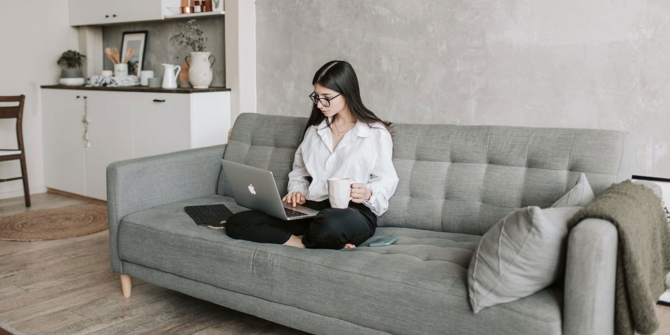 Woman sitting on sofa working on lapop