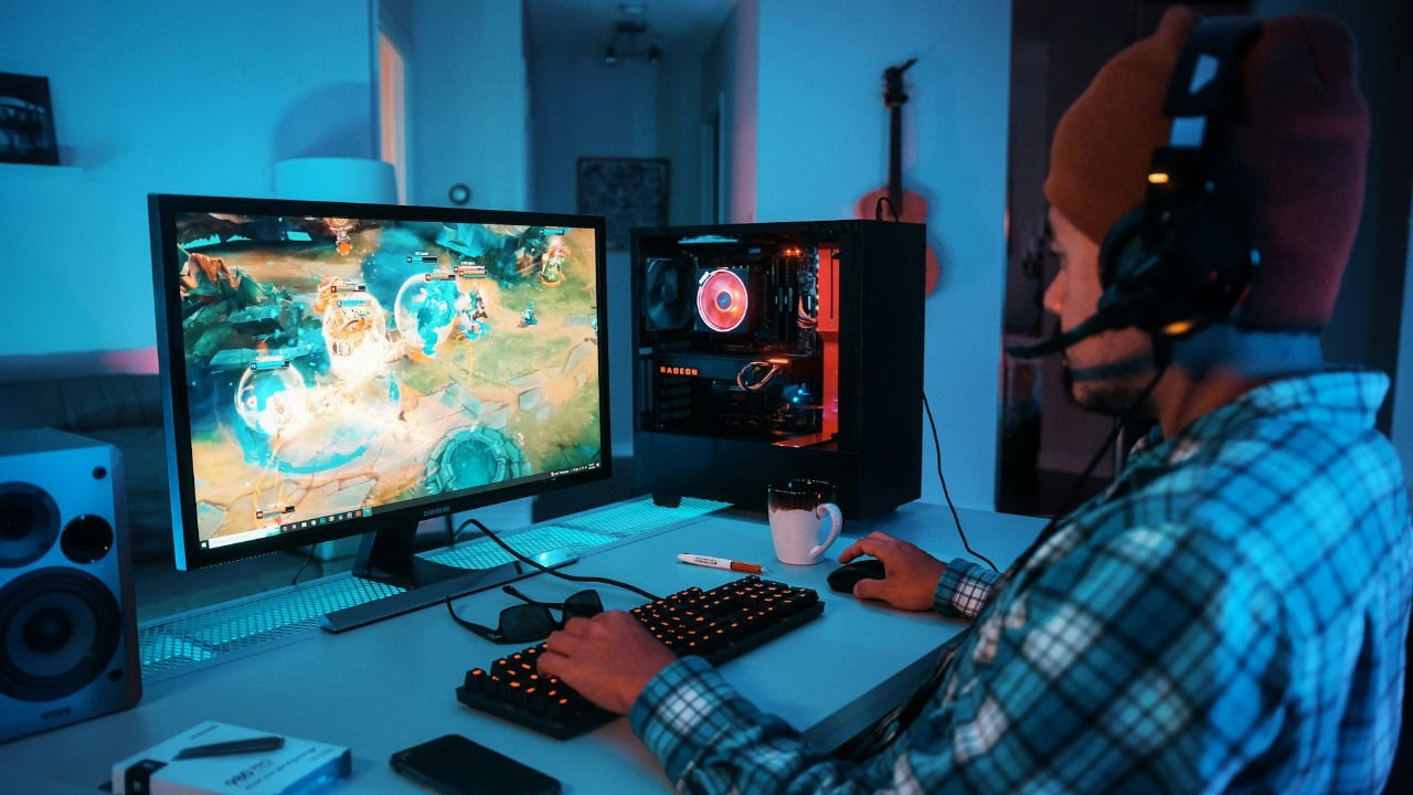 Man wearing headphones playing a game on a gaming PC