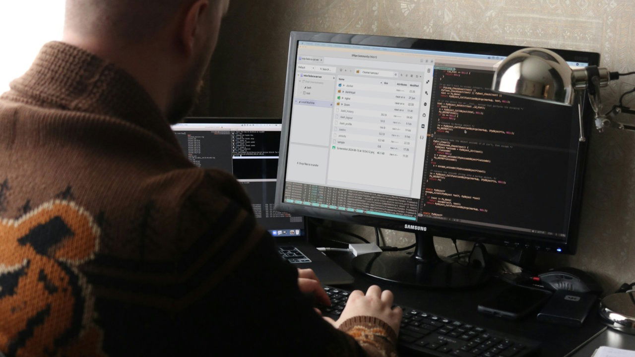 A photograph of a person working in front of a computer.