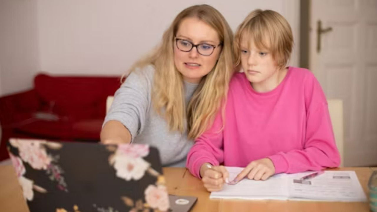 Woman helping teen with homework.