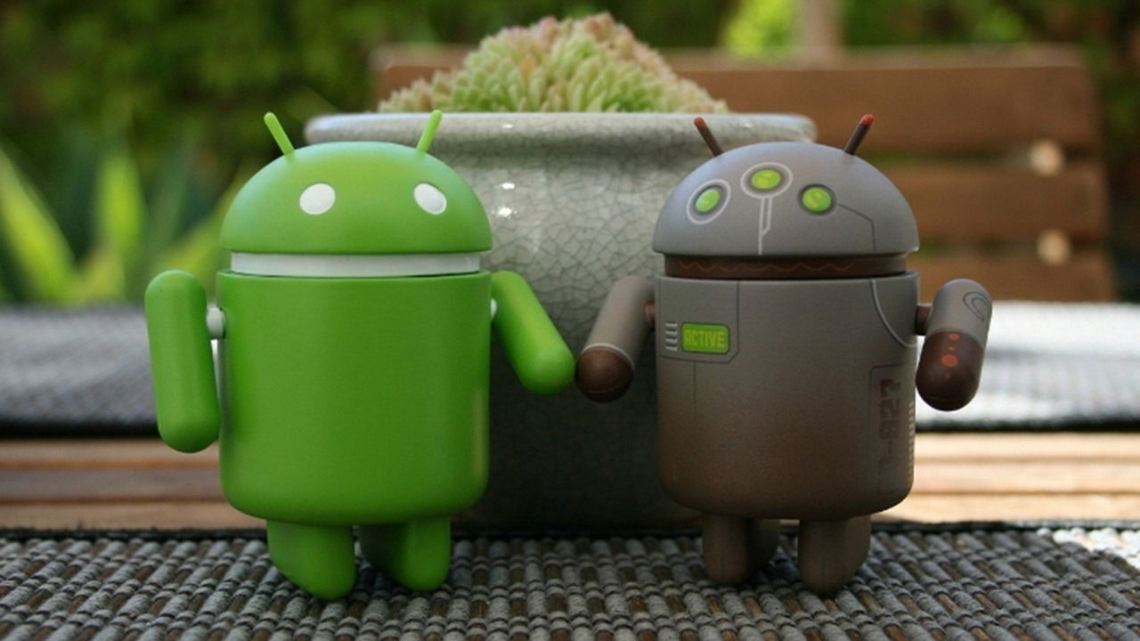 Two Android figures holding hands side by side.