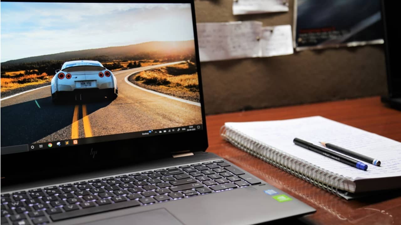 Laptop sitting on a desk with sports car on screen.