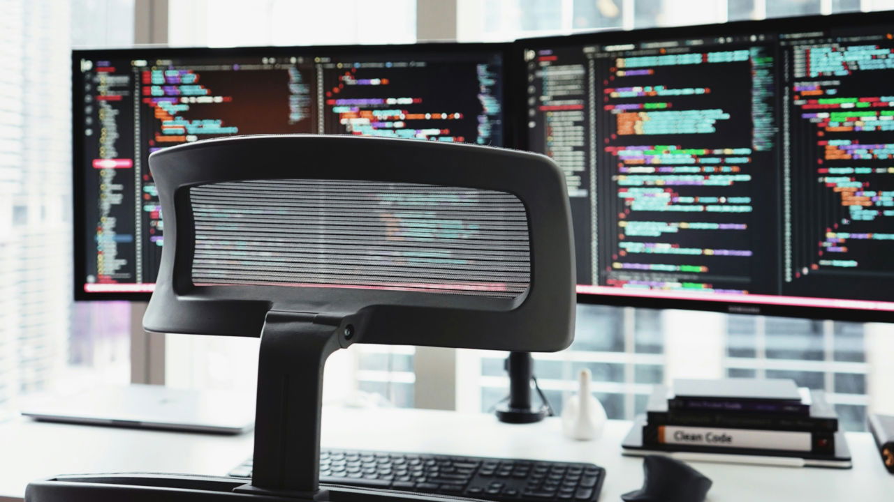 A photograph of two computer monitors showing copious amount of code.