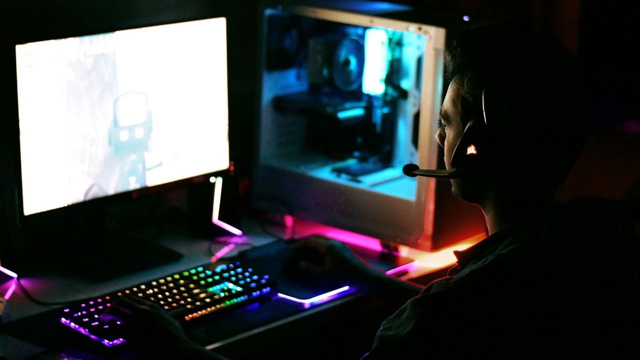 Person wearing headphones playing on a gaming pc