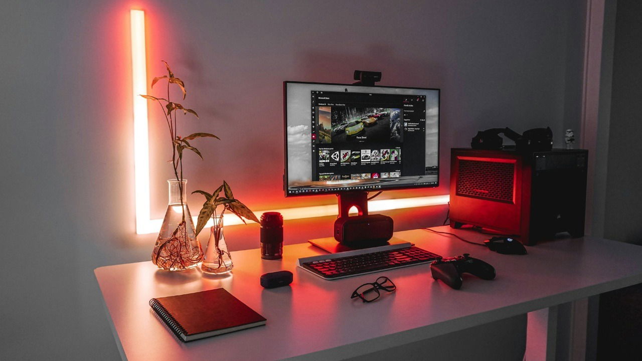 A gaming PC setup on a desk showing a monitor, PC, keyboard, mouse, and gamepad