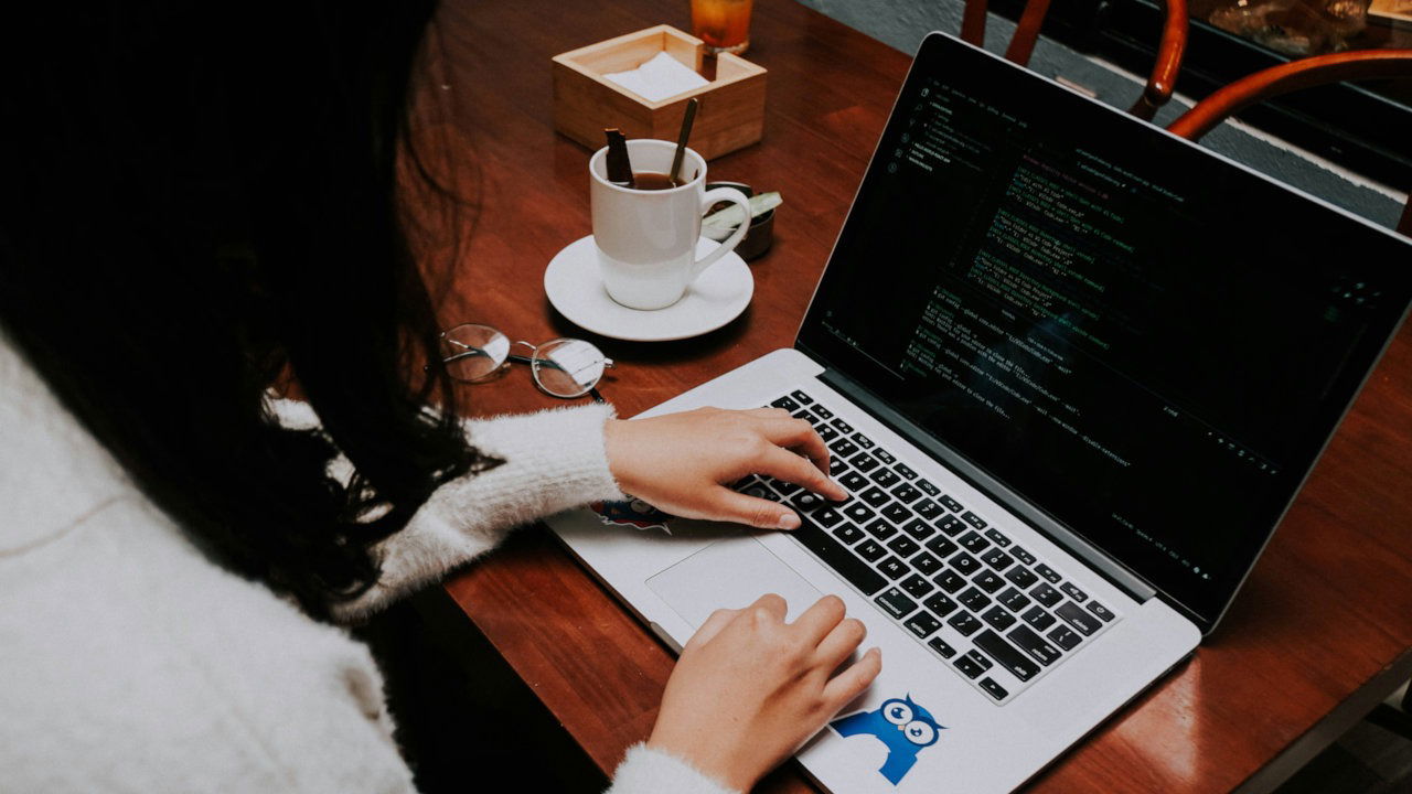 A photograph of a person programming on a laptop.