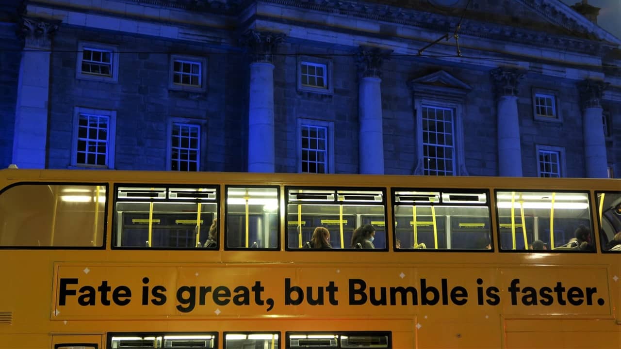 People on a bus that says Fate is great but Bumble is faster.