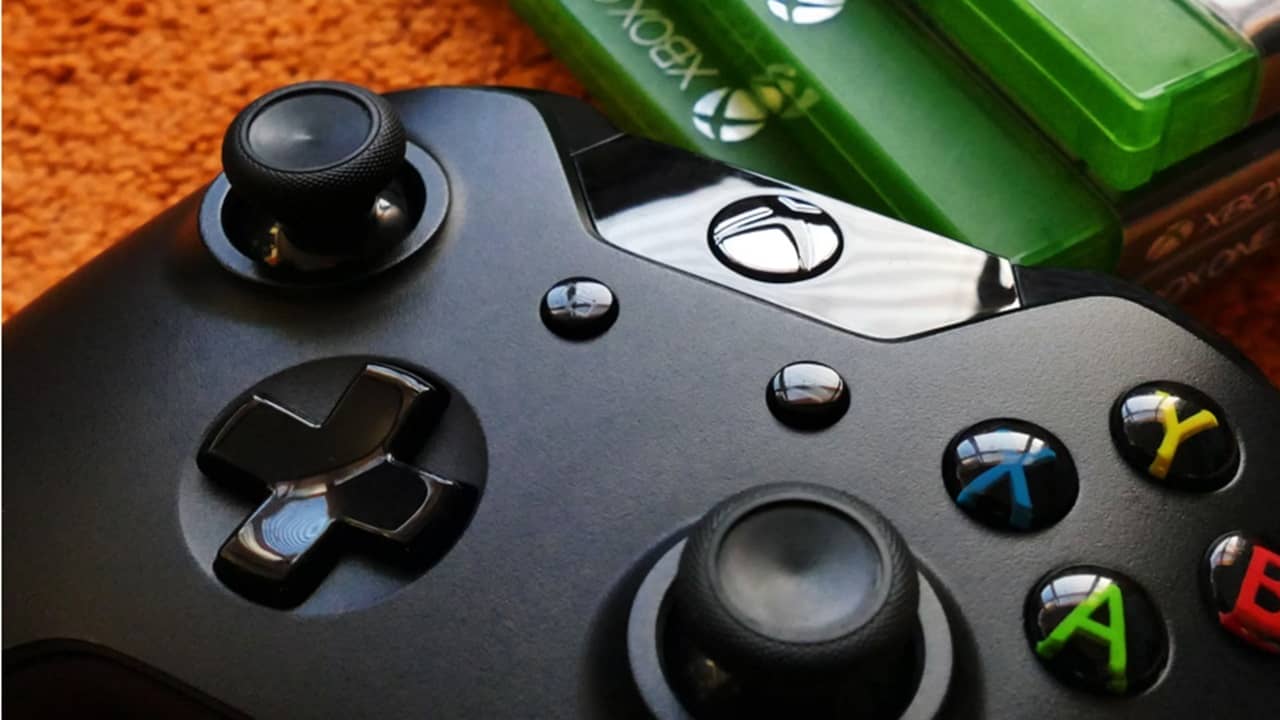 Xbox One controller beside games.